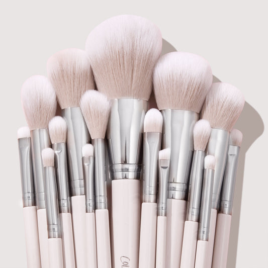 Stone Cold ColourPop Makeup Brush Kit fanned upright, displaying powder, blush, contour, and eye brushes with fluffy blush-pink bristles, silver ferrules, and pale pink handles, stacked tightly against a soft beige backdrop.