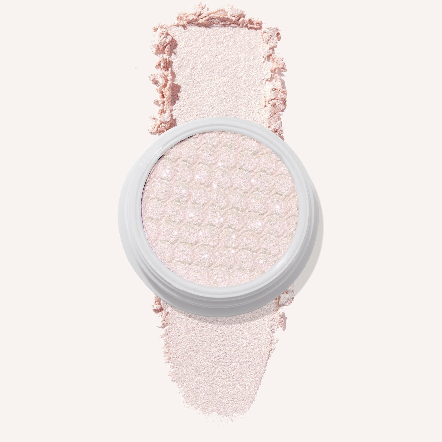 Colourpop Mountain Lion Super Shock Shadow single pan with a shimmery pale pink shade, showing its textured metallic finish and a soft swatch of the powder on a light background for detailed eyeshadow color payoff view.