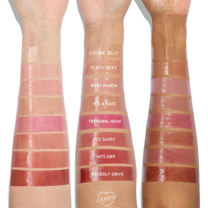 ColourPop So Juicy Lip Oil Set Juicy Moment swatches display glossy bands - Lychee Jelly, Flirty Text, Baby Panda, It’s a Date, Trending Now, So Sassy, Hits Diff, Beverly Drive - applied on three skin tones, studio lighting highlighting the high-shine finish.